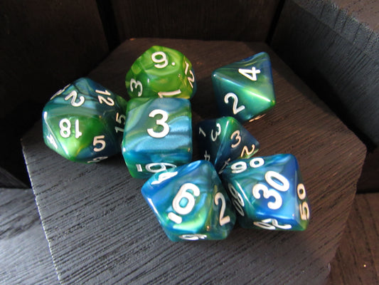 Set of green and blue polyhedral dice on a wooden surface