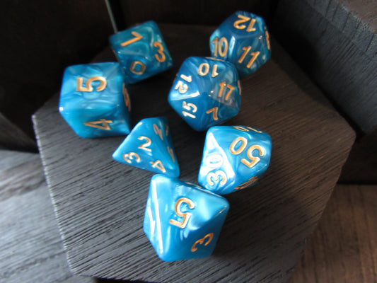 Blue polyhedral dice with gold numbers on a wooden surface