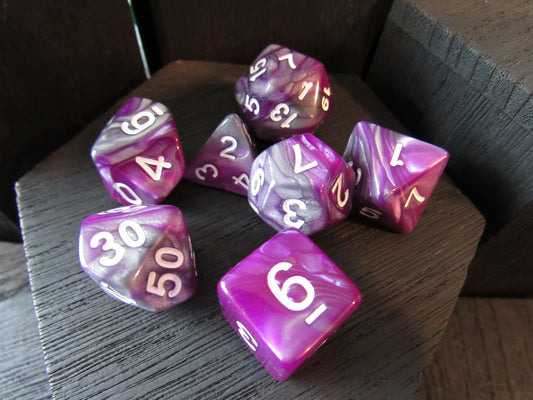 Purple and gray marbled dice set on a wooden surface