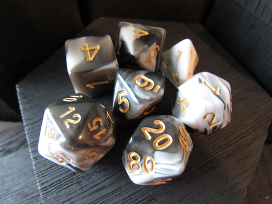 Set of polyhedral dice with gold numbers on a dark surface