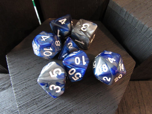 Set of blue and gray polyhedral dice on a wooden surface