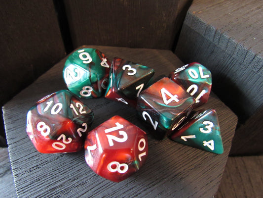 Set of polyhedral dice with red, green, and black colors on a wooden surface.