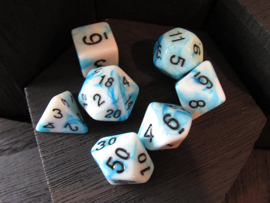 Set of dice with blue and white marbled pattern on a wooden surface