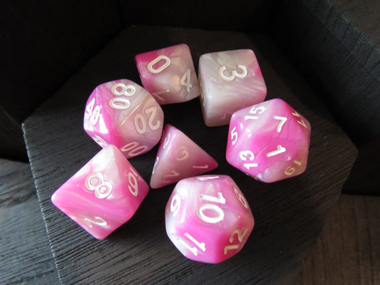 Pink polyhedral dice set on a dark surface