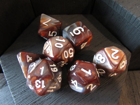 Set of polyhedral dice with brown and white colors on a dark surface