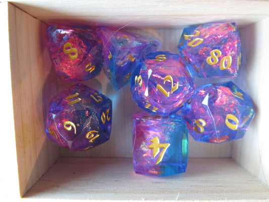 Set of colorful polyhedral dice with gold numbers in a wooden box. gem gemstone cut faceted resin dice