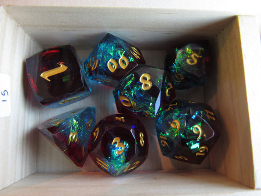 Set of colorful polyhedral dice with gold numbers in a cardboard box. gem gemstone crystal cut faceted resin dice