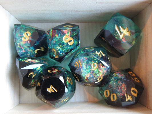 Set of colorful polyhedral dice with gold numbers in a box. gem gemstone cut faceted resin dice