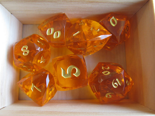 Set of orange polyhedral dice with gold numbers in a wooden box gem gemstone cut faceted resin dice