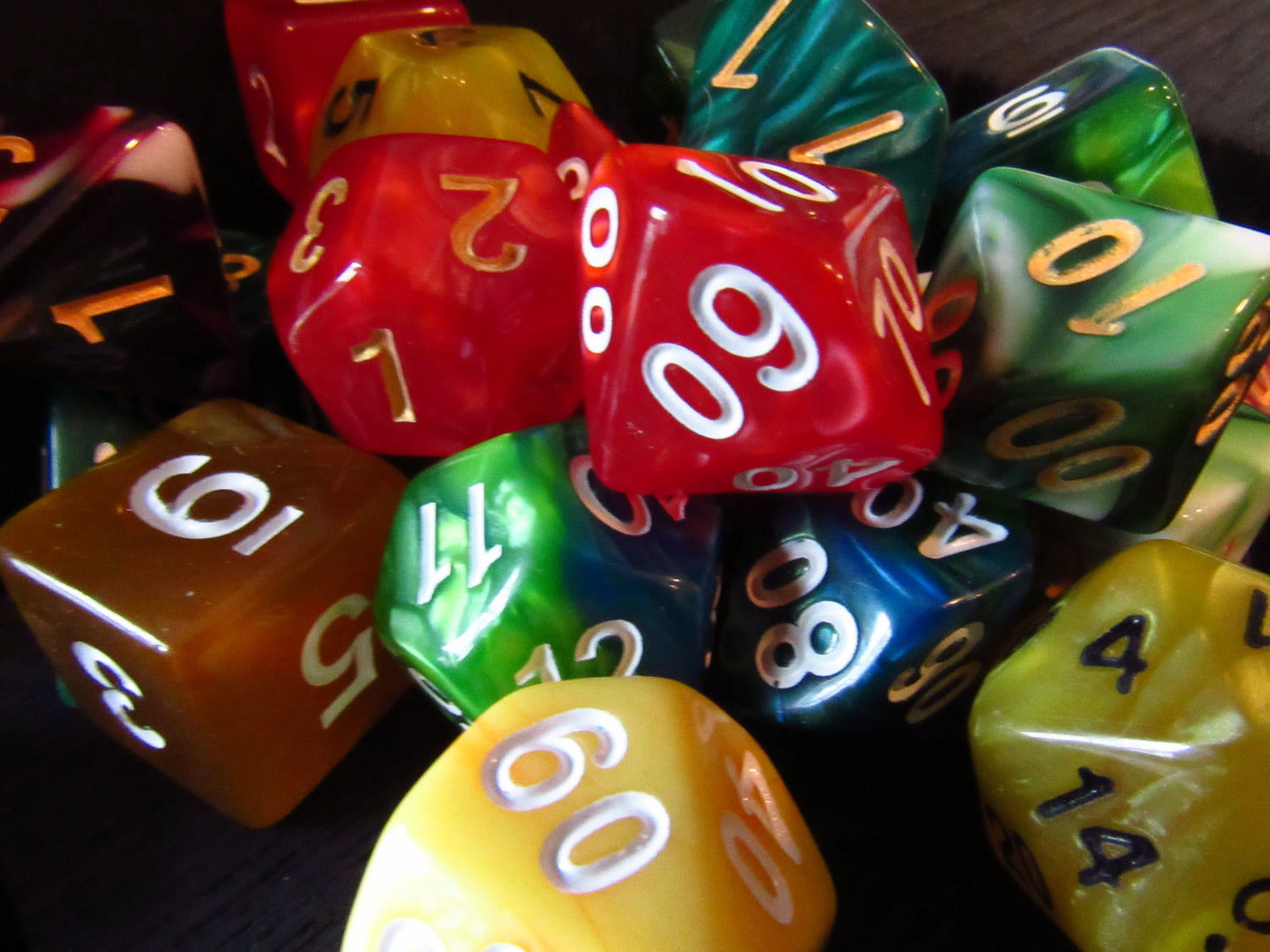 a pile of mixed colored acrylic polyhedral dice