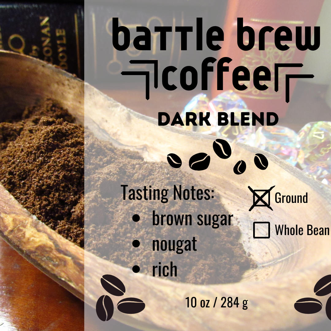 Wooden scoop filled with ground coffee next to a label for Battle Brew Coffee Dark Blend.