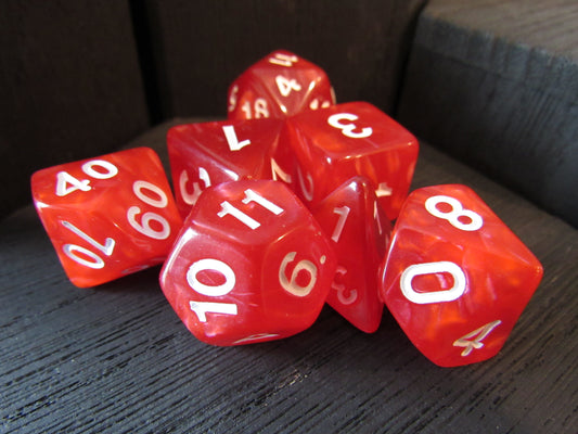 Red dice with white numbers on a dark surface