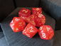 Red polyhedral dice with gold numbers on a dark surface