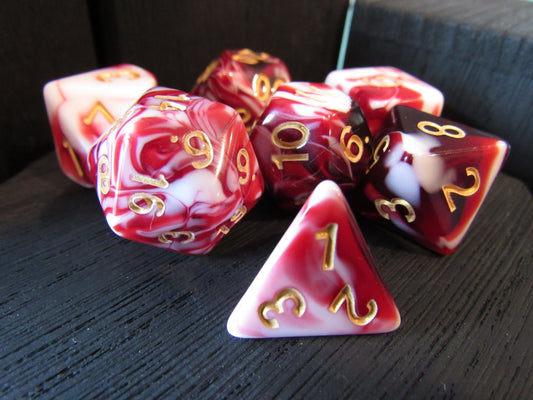 Set of red and white dice with gold numbers on a dark surface