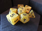 Set of yellow polyhedral dice with black numbers on a dark textured surface