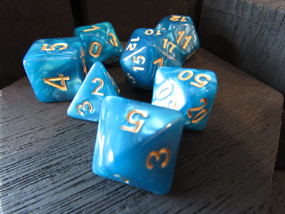 Blue polyhedral dice with gold numbers on a wooden surface