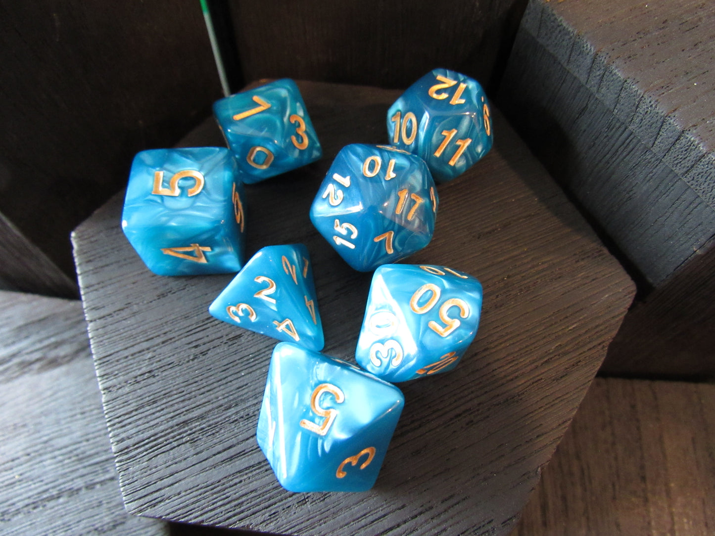 Blue dice with yellow numbers on a wooden surface