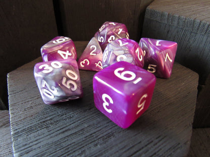 Purple and white dice set on a wooden surface