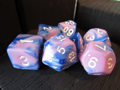 Set of blue and pink dice with white numbers on a dark surface