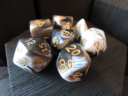 Set of polyhedral dice with gold numbers on a wooden surface