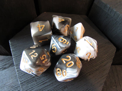 Set of polyhedral dice with gold numbers on a dark surface