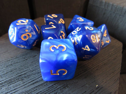 Blue dice with gold numbers on a wooden surface