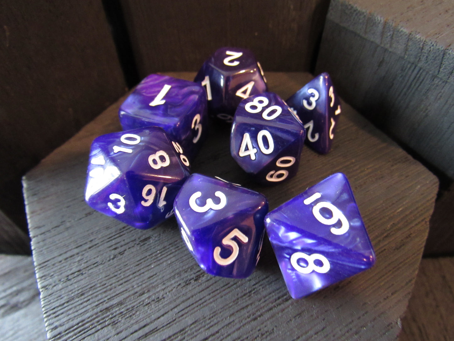 Purple polyhedral dice set on a wooden surface