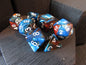 Set of polyhedral dice with blue and orange colors on a wooden surface