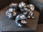 Set of polyhedral dice with white numbers on a wooden surface