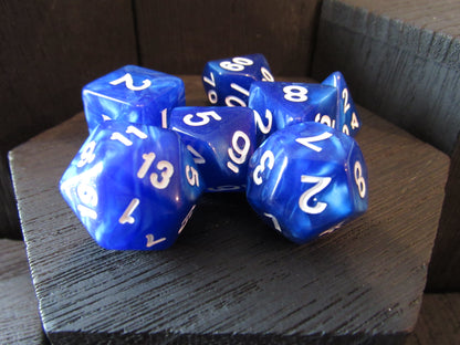 Blue polyhedral dice set with white numbers on a wooden surface