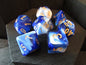 Set of blue and white dice with yellow numbers on a wooden surface