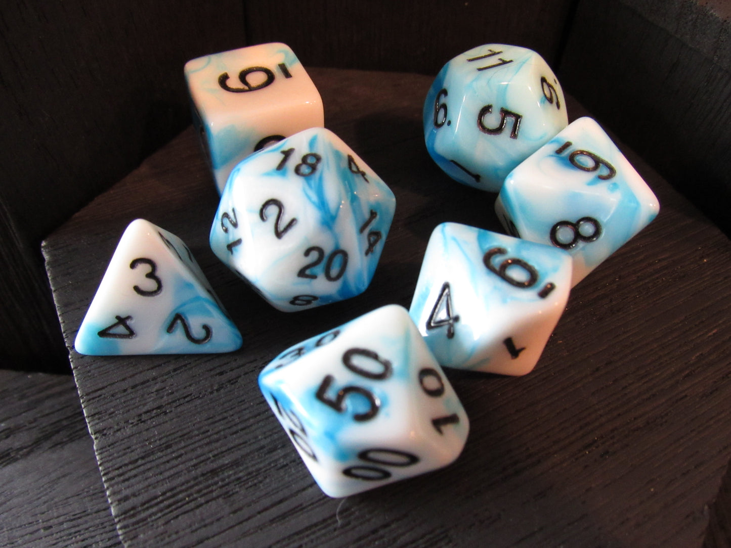 Set of dice with blue and white marbled pattern on a wooden surface