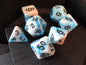 Set of dice with blue and white marbled pattern on a wooden surface