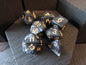 Set of black polyhedral dice with gold numbers on a wooden surface