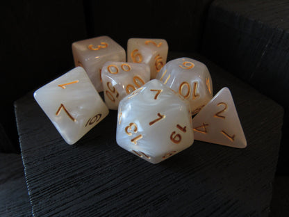 Set of white dice with gold numbers on a dark surface