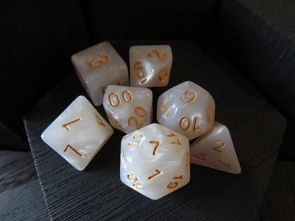 Set of white dice with gold numbers on a dark surface