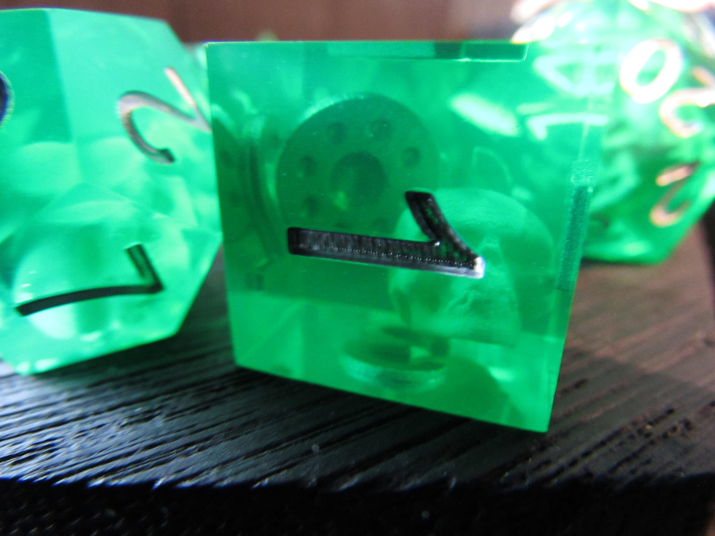 Green dice with number 1 on a dark surface gelatinous cube skeleton skull shield inside gel cube