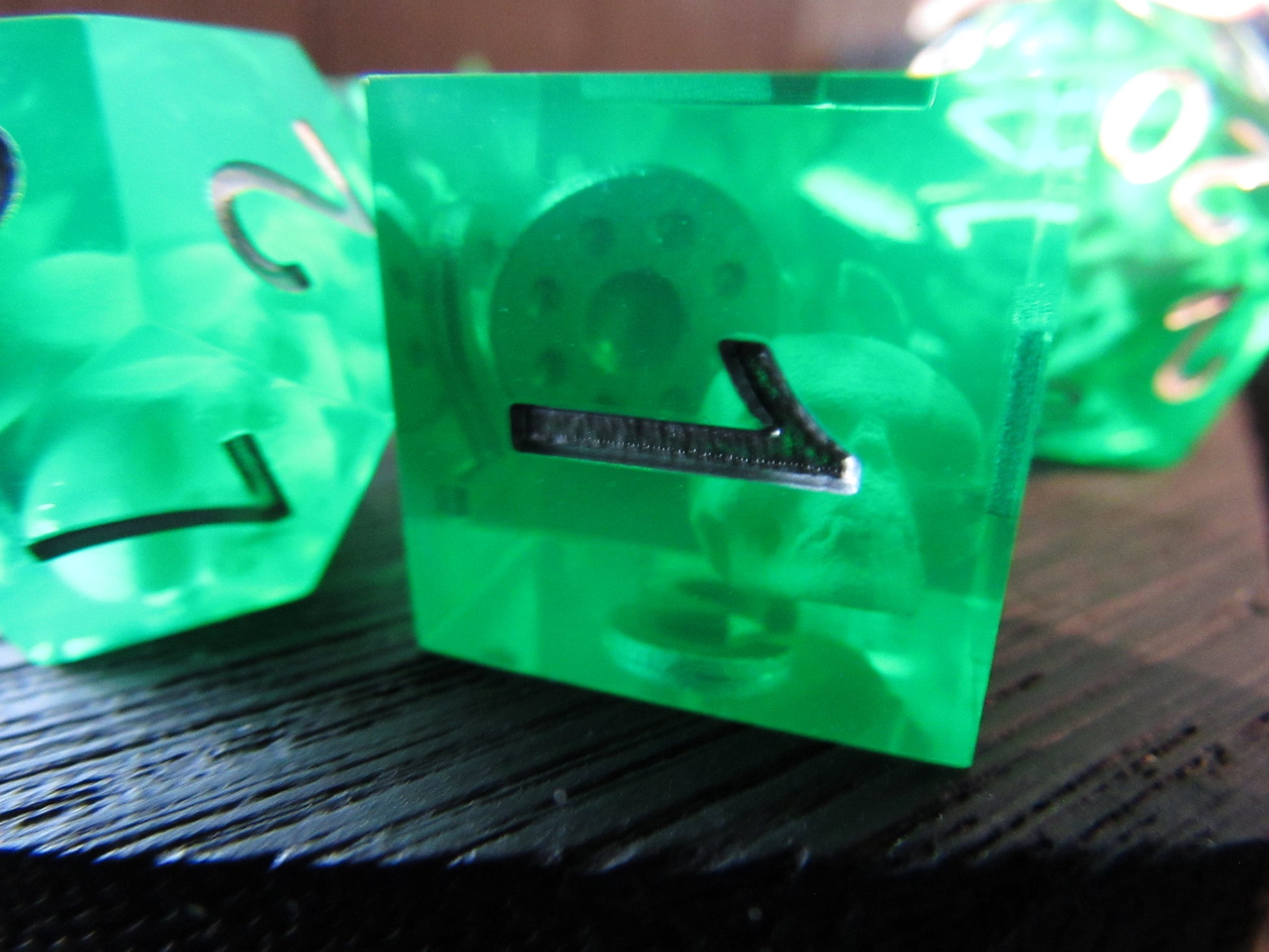 Green dice with number 1 on a dark surface gelatinous cube skeleton skull shield inside gel cube