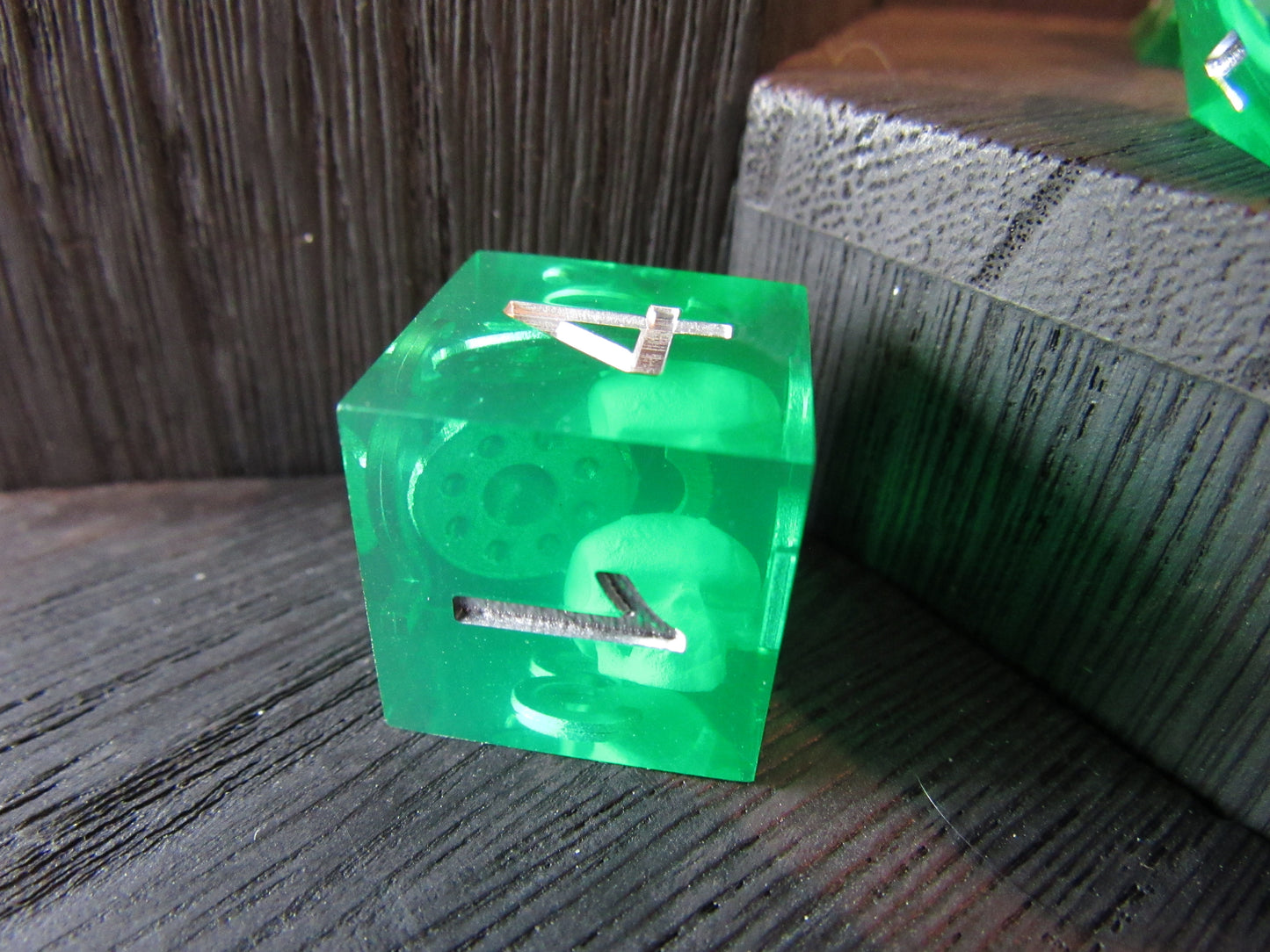 Green transparent cube with a number '4' on a wooden surface gelatinous cube dice