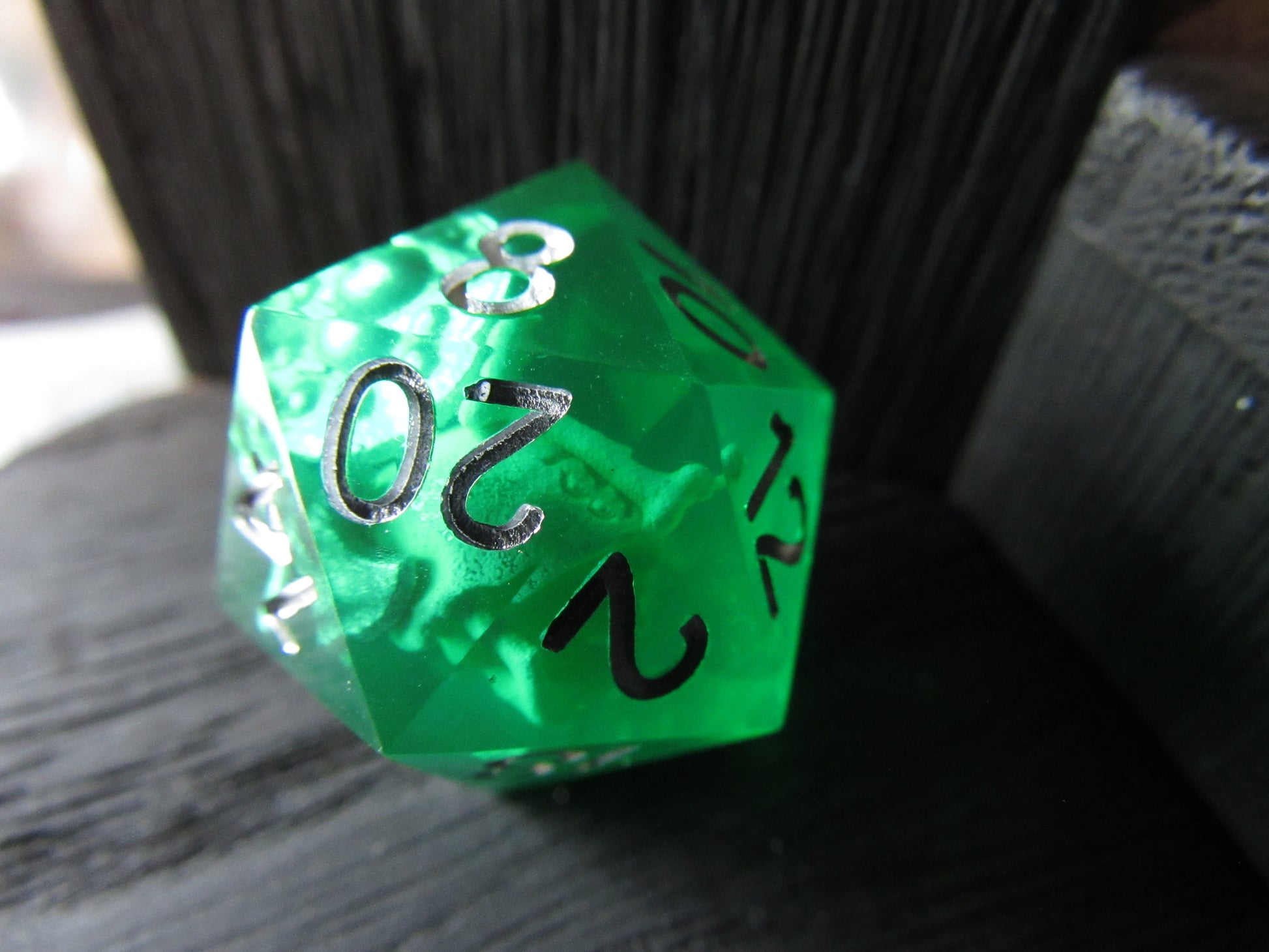 Green polyhedral dice with numbers on a wooden surface gelatinous cube