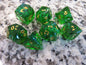 Green polyhedral dice set with gold numbers on a gray marble surface gem gemstone crystal cut faceted resin dice