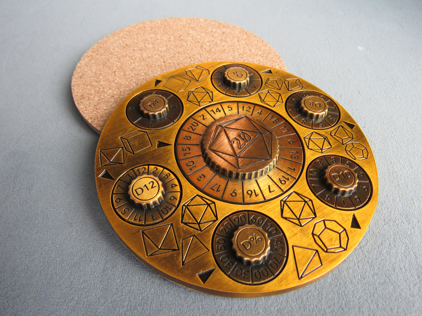 Decorative brass plate with geometric designs and numbers on a gray background dice dnd dungeons and dragons