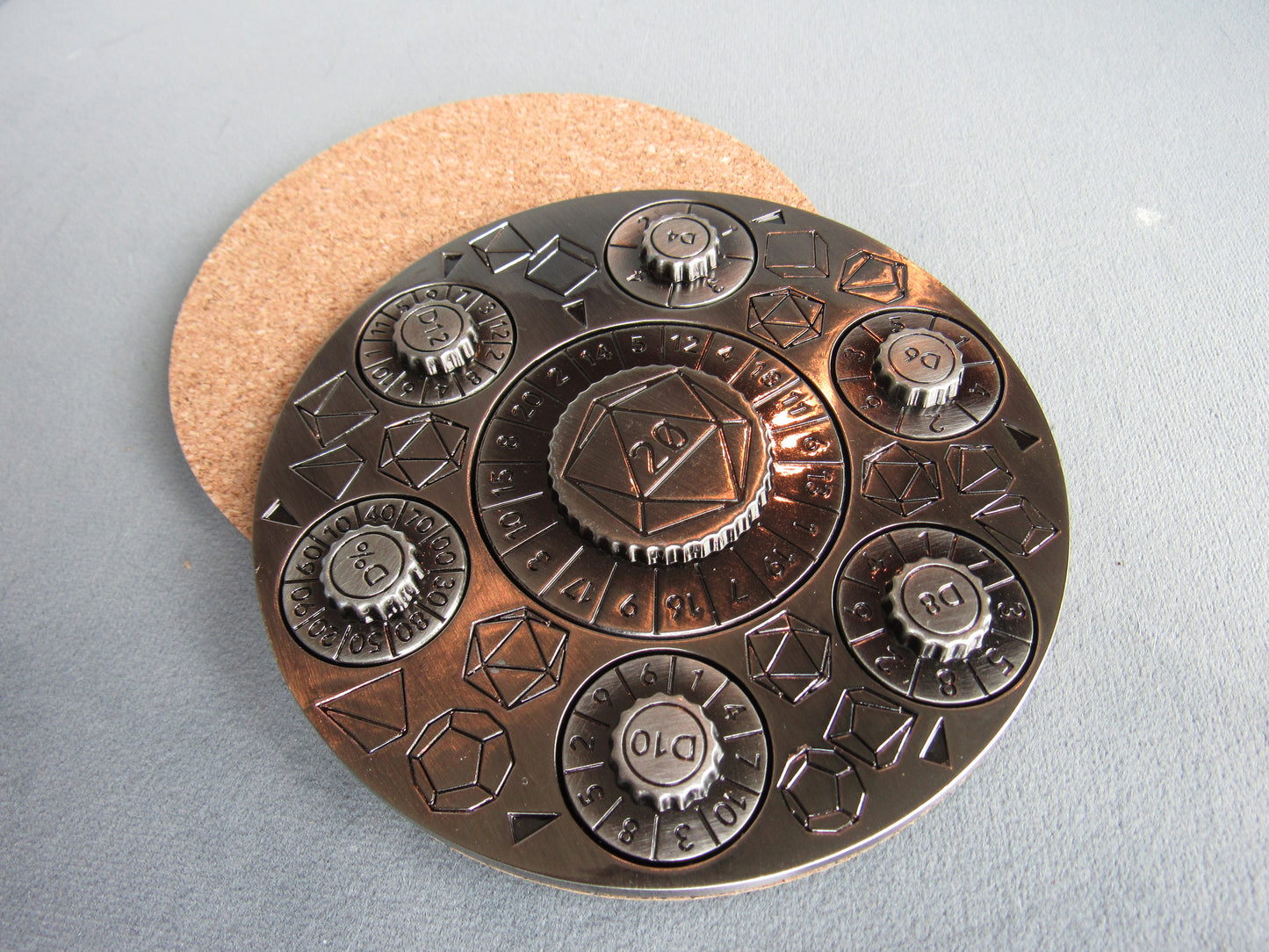 Decorative metal coaster with geometric designs on a gray surface dungeons and dragons spinner dice silver